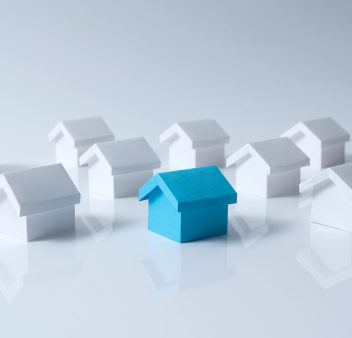 Blue house in among white houses for real estate property industry